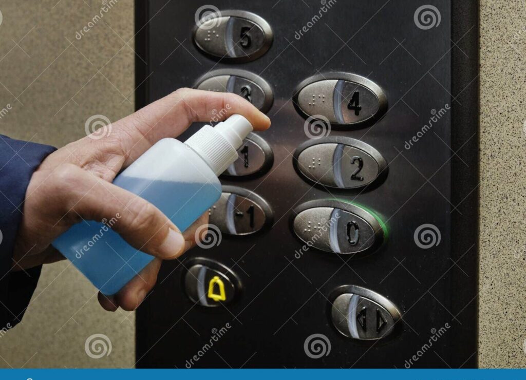 mano desinfectando boton de ascensor